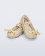 Angled view of a pair of pearly beige Sophie Crush baby ballerina flats with bow