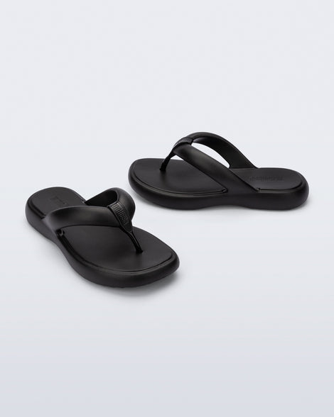 Side and angled view of a pair of black Free Low flip flops
