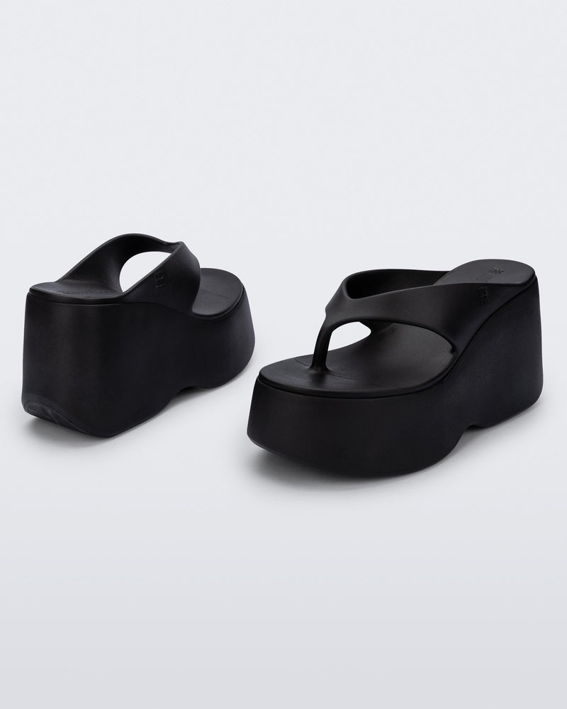 Back and angled view of a pair of black Free Thong Wedge Platform heels