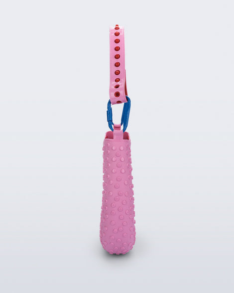 side view of a pink Nina Bag + Alexandre Pavao shoulder bag with red accents