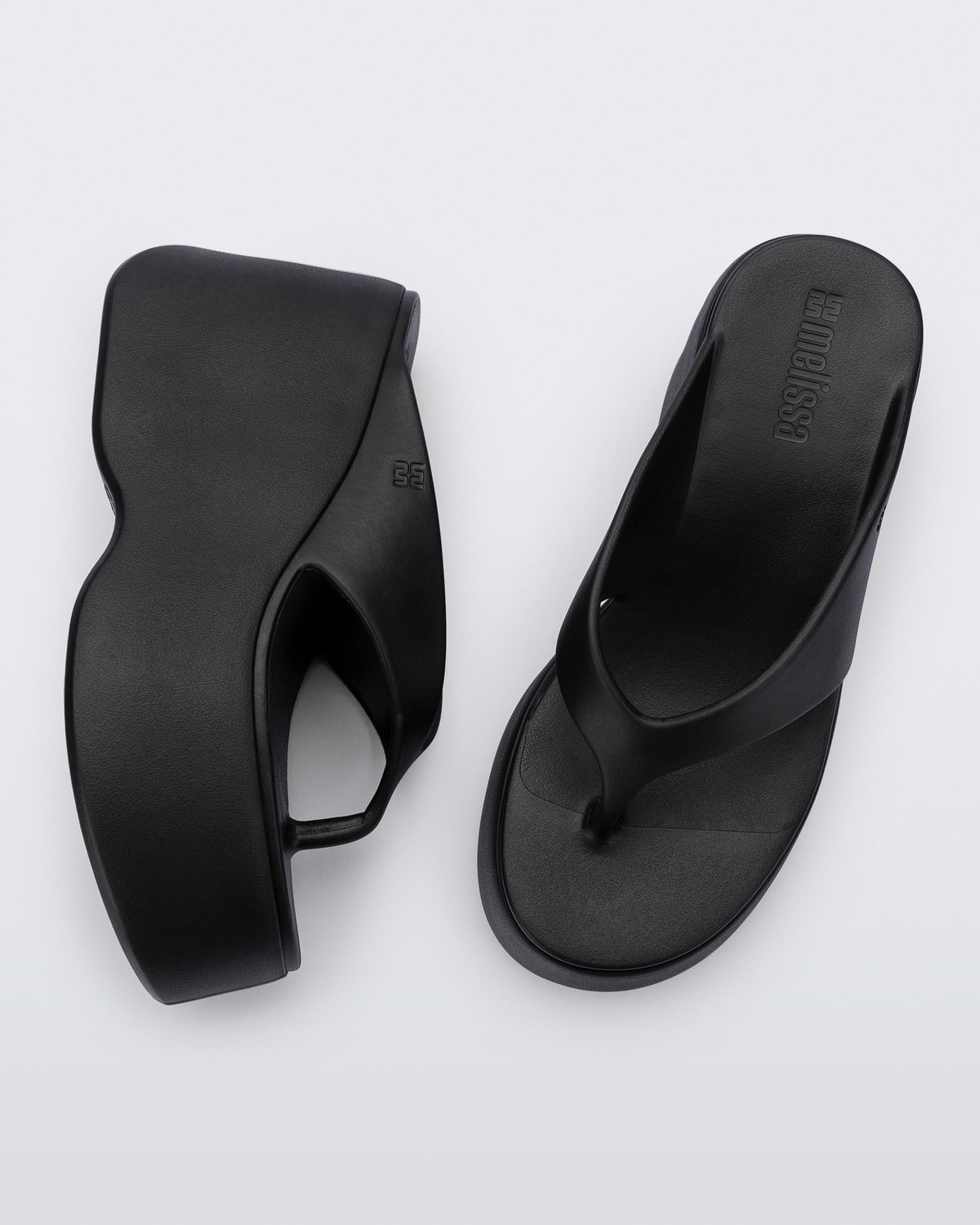 Top and side view of a pair of black Free Thong Wedge Platform heels
