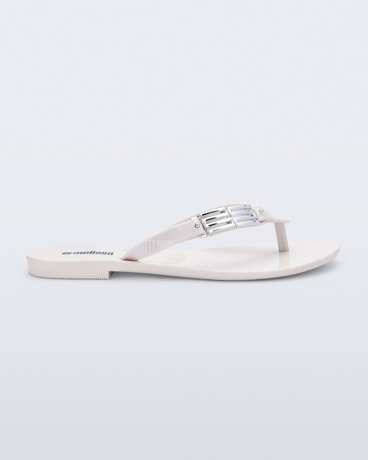 Side view of a white Harmonic M Chic flip flop
