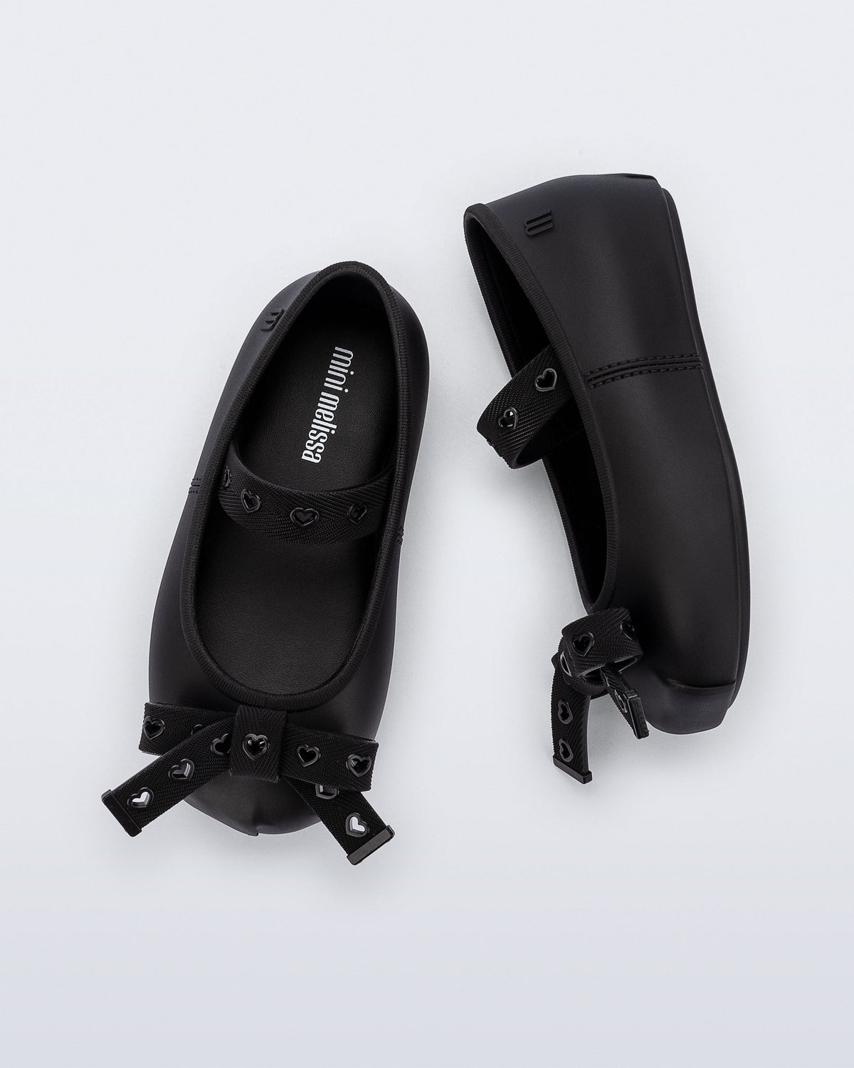 Top and side view of a pair of black Sophie Crush baby ballerina flats with bow