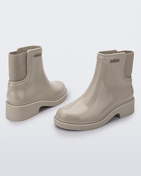Back and angled view of a pair of beige Chelsea boots