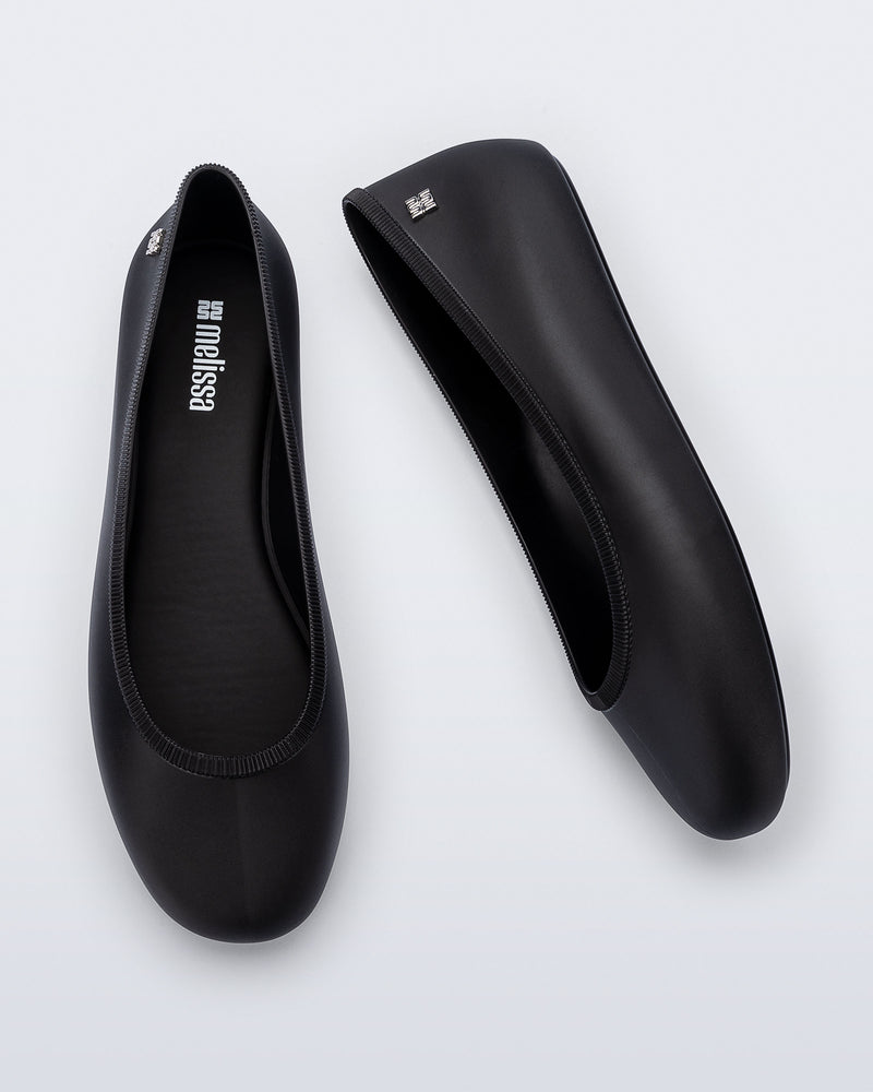 Top and side view of a pair of black Soft Ballerina Essential flats
