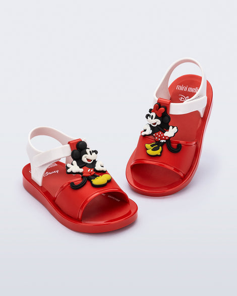 Angled view of a pair of red Play Mickey & Minnie sandals with white straps
