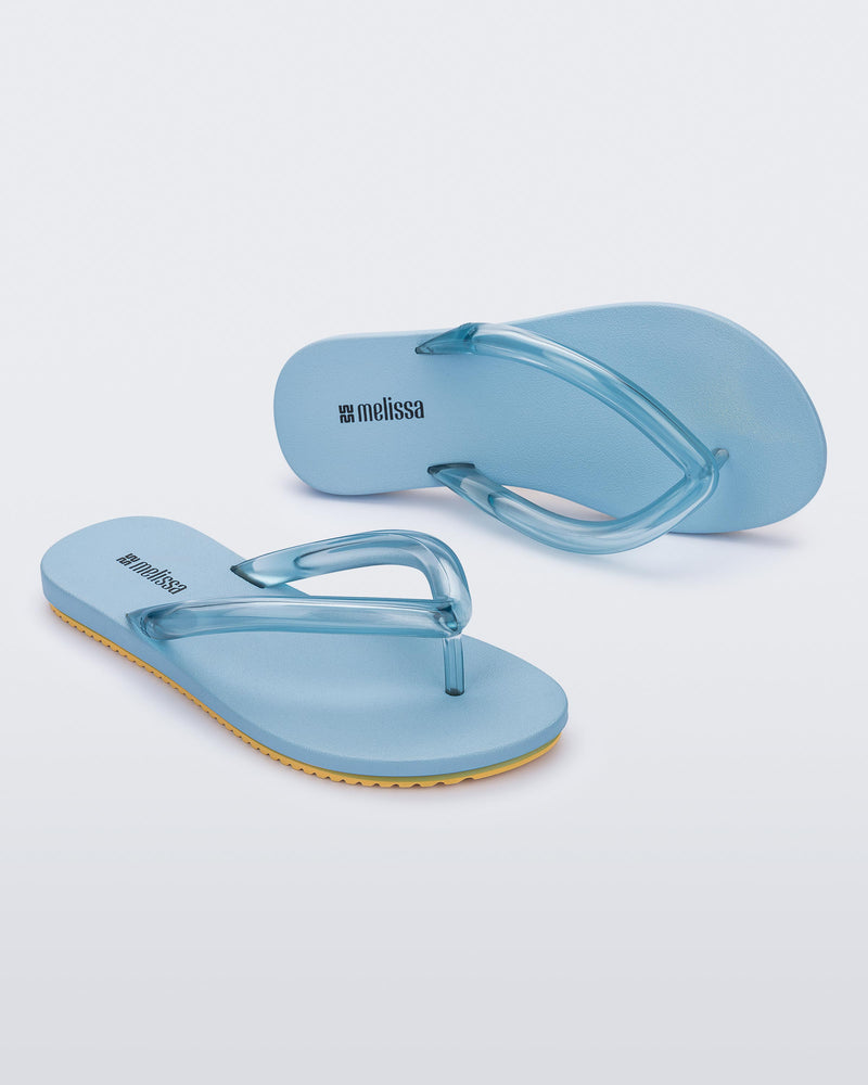 Top and angled view a pair of blue Flip Flop Airflow sandals with a clear blue strap and yellow bottom