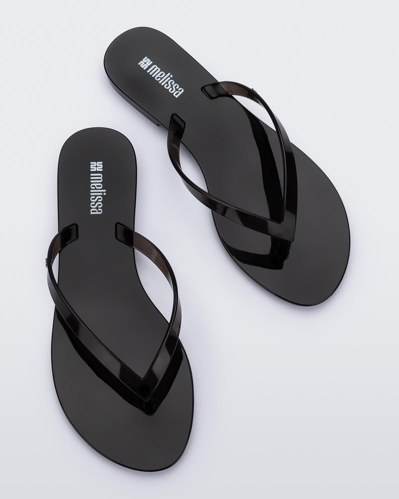 Top view of a pair of clear black Harmonic Jelly flip flops