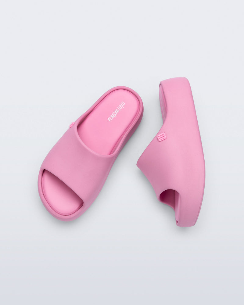 Top and side view of a pair of pink Free Platform Slide kids sandals