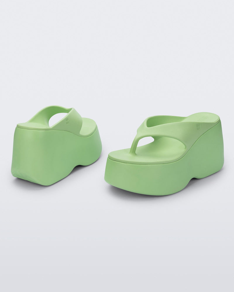Back and angled view of a pair of green Free Thong Wedge Platform heels