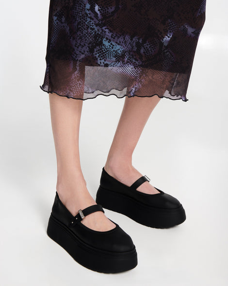 Model's lets in a pair of black Soft Ballerina Platform flats