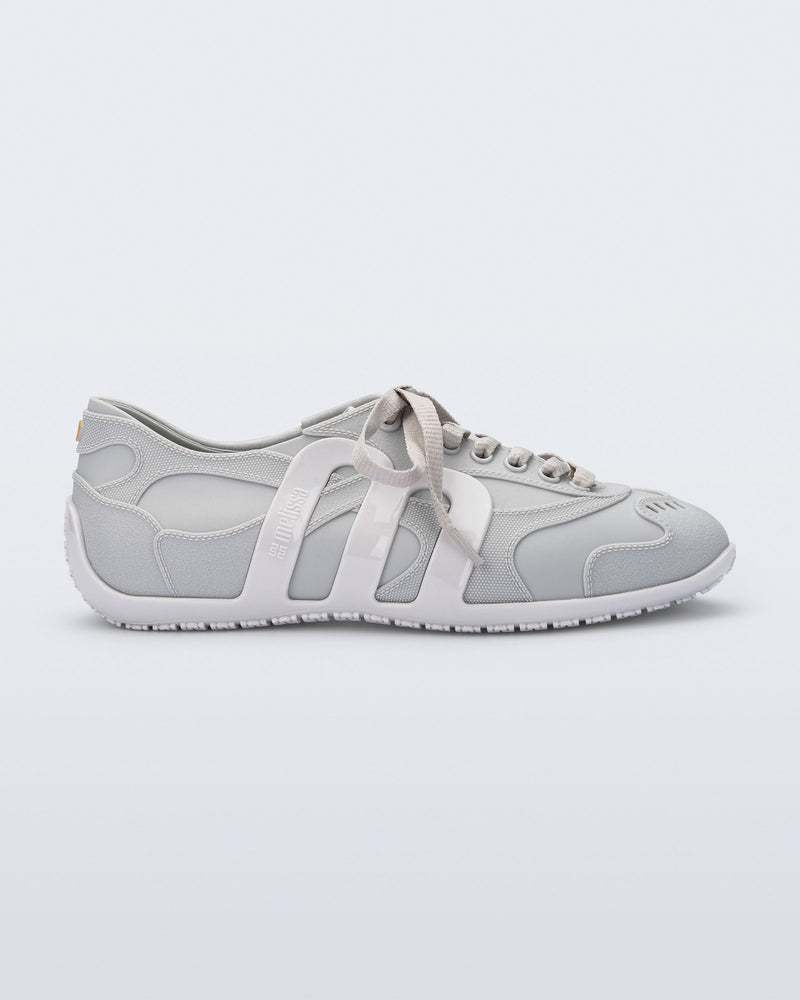 Side view of a grey Motion sneaker with white colored sole and M monogram