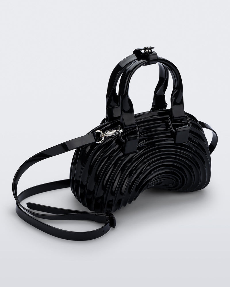 Angled view of a black Quantum Dome + Diesel bag with hand strap and shoulder strap