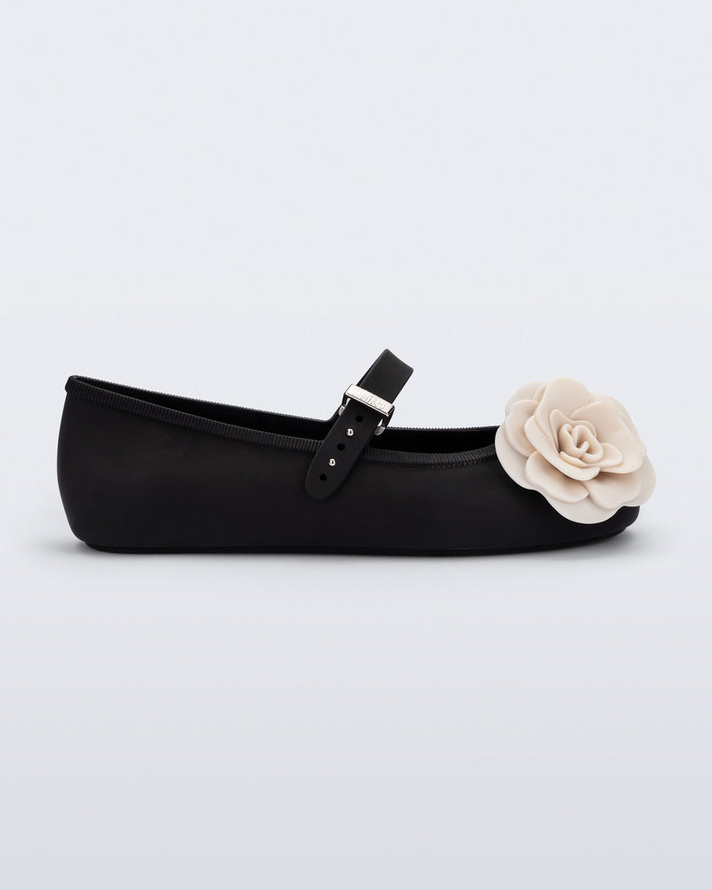 Side view of a black Soft Ballerina Petals flat with beige flowers