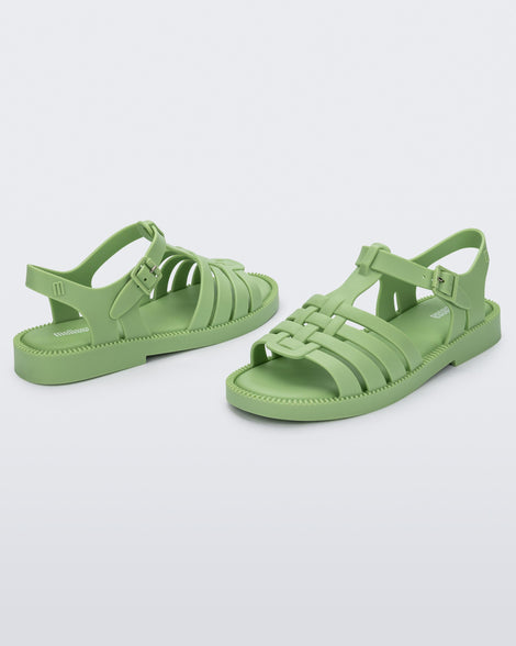 Angled view of a pair of matte green Possession Fresh fisherman style sandals with open toe.