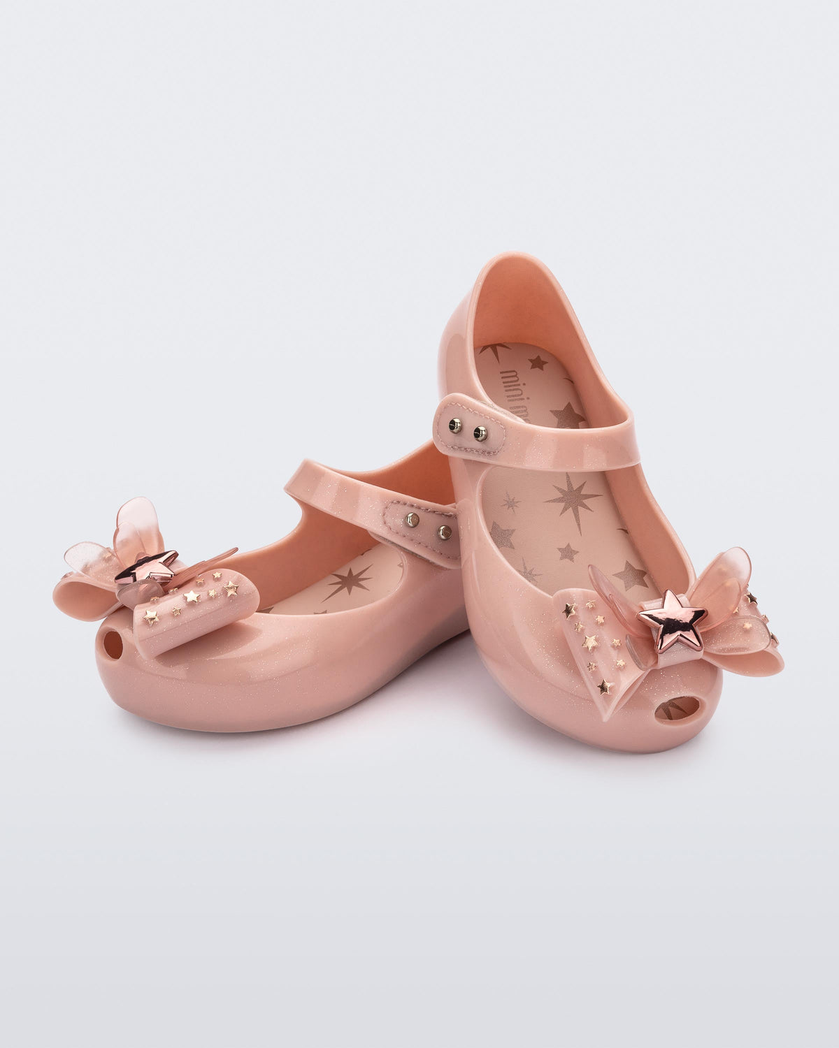 Angled view of a pair of Mini Melissa Ultragirl peeptoe ballet flats for baby in pink with star printed butterfly bow applique.