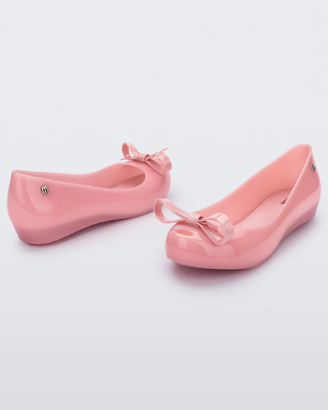 Angled view of a pair of pink Ultragirl Bow flat