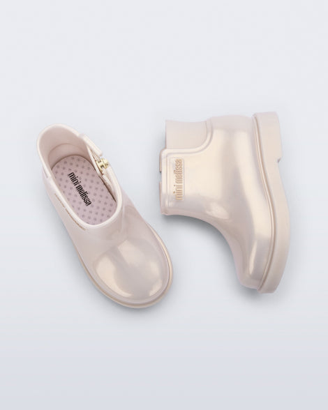 Top and side view of a pair of pearly beige Chelsea II baby boots