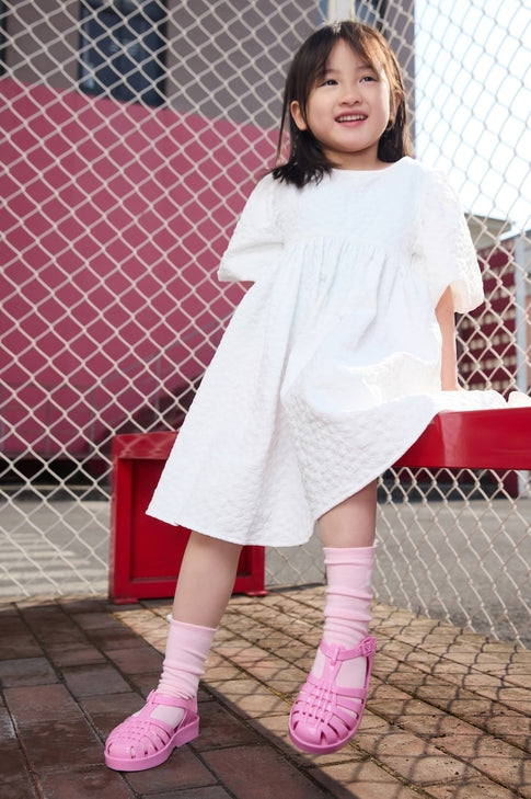 little girl model wearing the pink mini possession sandals