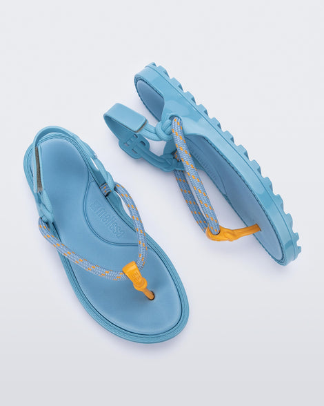 Top and side view of a pair of blue Bond sandals with textile strap and orange toe piece