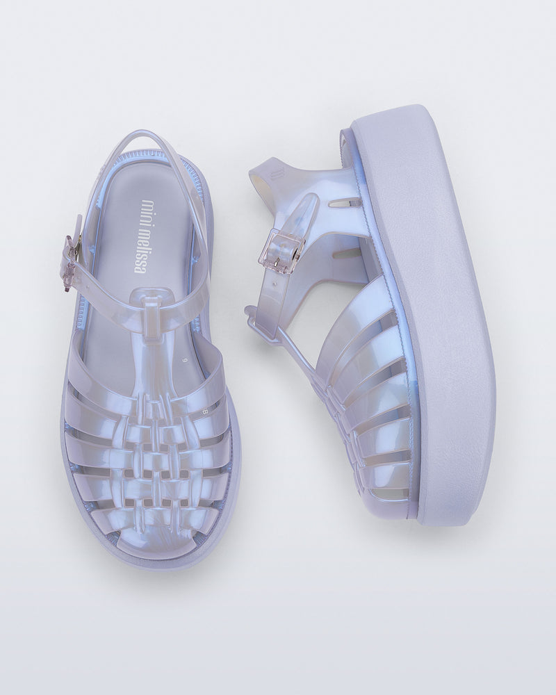 Top and side view of a pair of pearly blue Possession Platform kids fisherman sandals with lilac soles