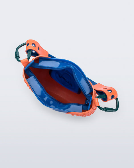 Top view of an orange Nina Bag + Alexandre Pavao shoulder bag with blue accents
