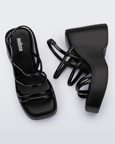 Side and top view of a pair of black Jessie platform wedge sandals with side buckle ankle strap