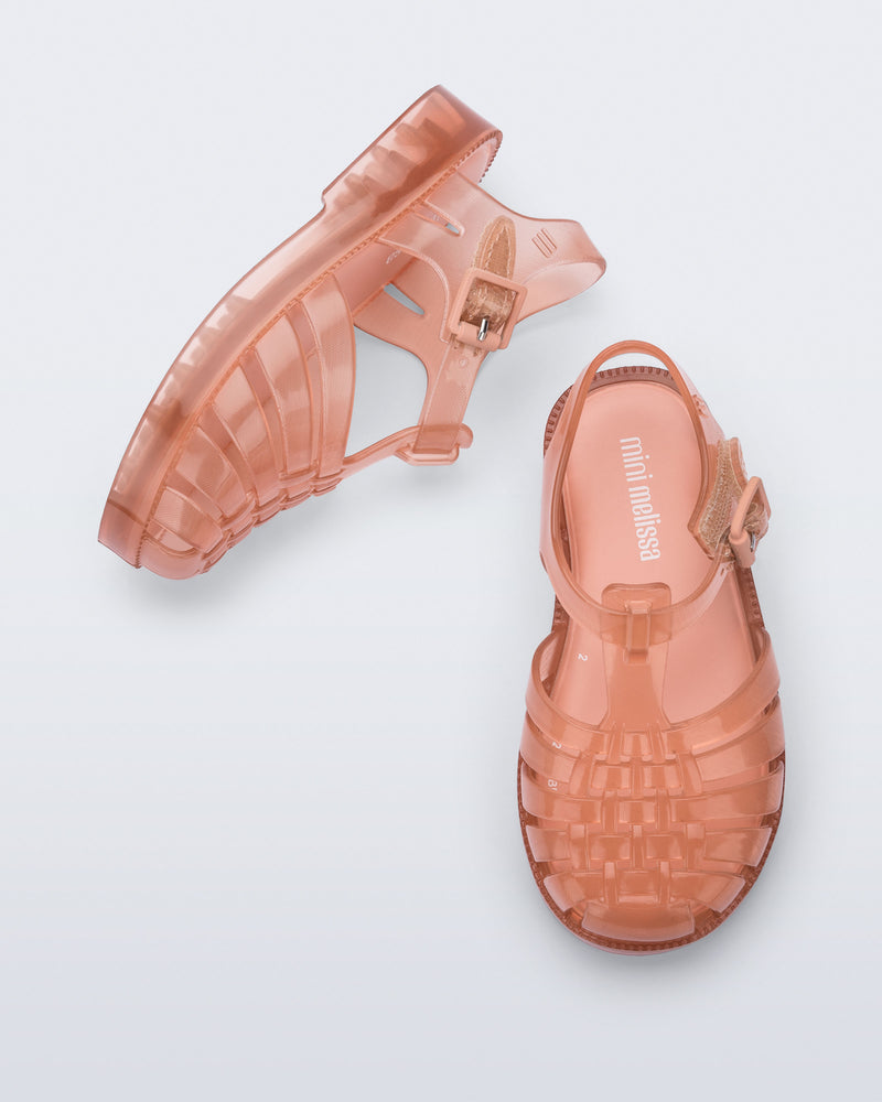 Side and top view of a pair of clear beige/pink Possession baby sandals