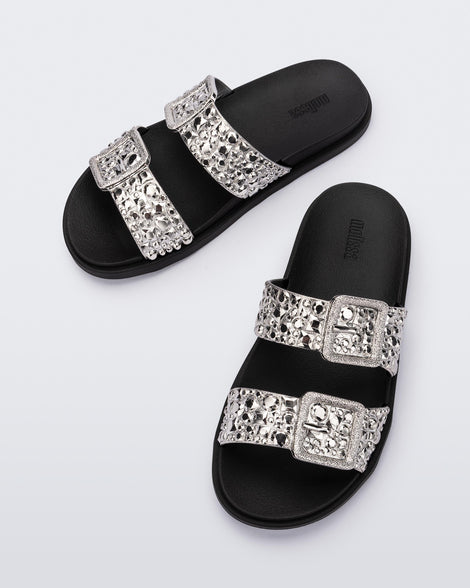 Top view of a pair of black Lust Slide with silver metallic buckle straps