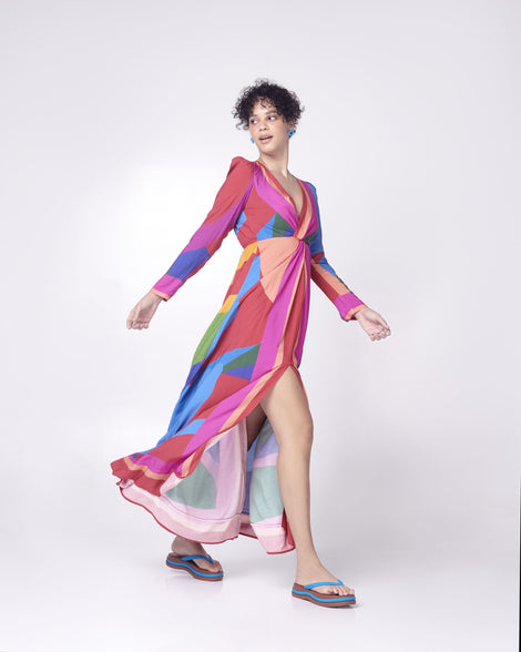 A model posing for a picture in a patterned dress, wearing a pair of brown/blue Melissa Leblon platform flip flops with details that mimic sisal braids on the sole and strap