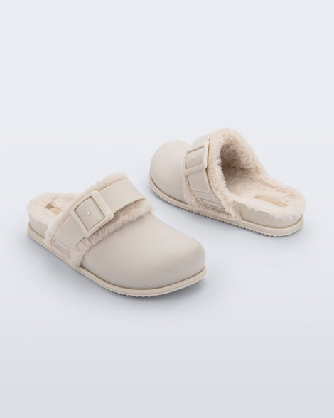 Back and angled view of a pair of beige Cozy Warm Clogs with fuzzy insoles