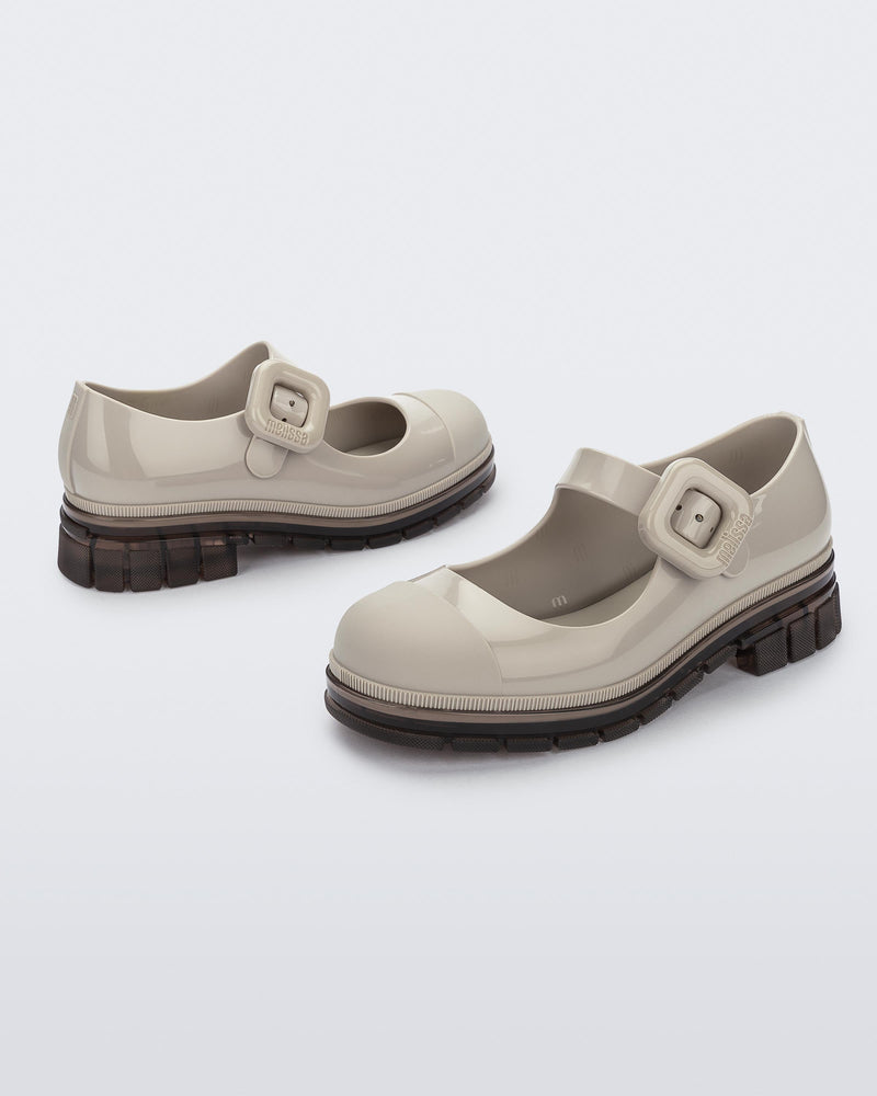 Back and side angle view of a pair of beige with brown sole June kids mary janes with matte toe cap