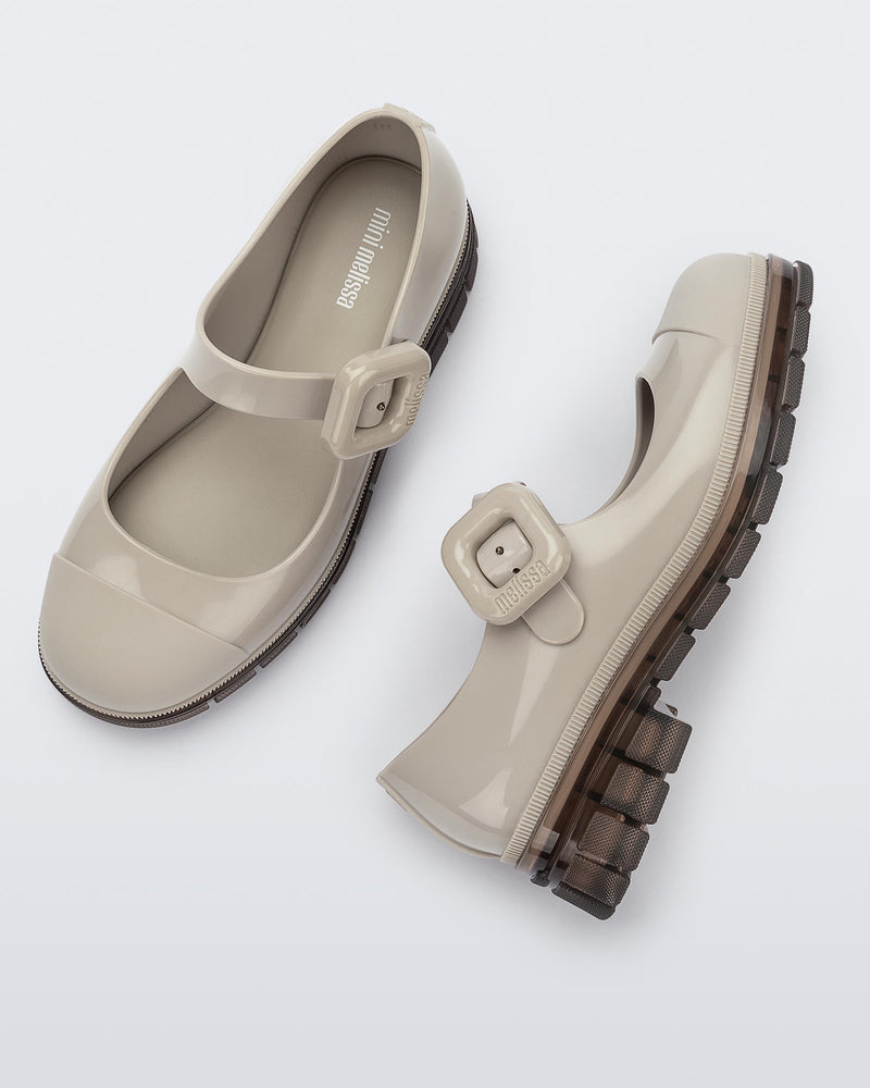 Top and side view of a pair of beige with brown sole June kids mary janes with matte toe cap