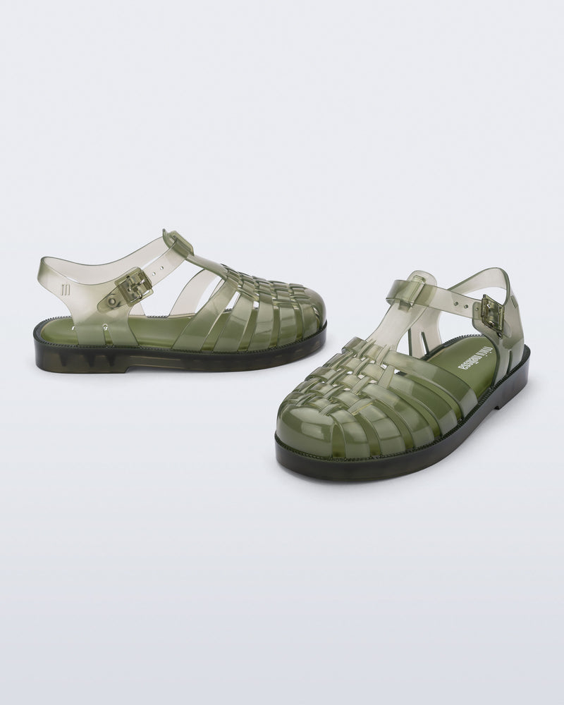 Side and angled view of a pair of transparent green Possession kids sandals