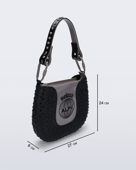 Angled view of a black Nina Bag + Alexandre Pavao shoulder bag with grey accents with purse dimensions of 27cm x 6cm x 24cm