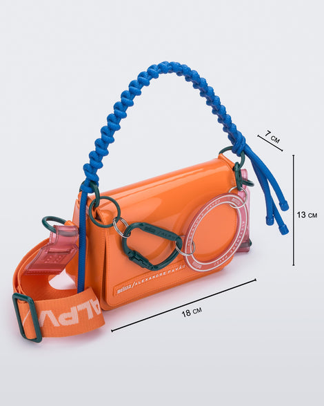 Angled view of an orange Olga Bag + Alexandre Pavao with blue short strap fabric long strap. With purse dimensions of 18cm x 7cm x 13cm