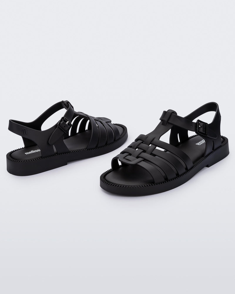 Angled view of a pair of matte black Possession Fresh fisherman style sandals with open toe.