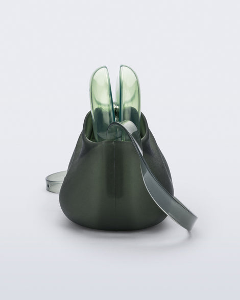 Side view of a small green bag with clear green clutch and long strap