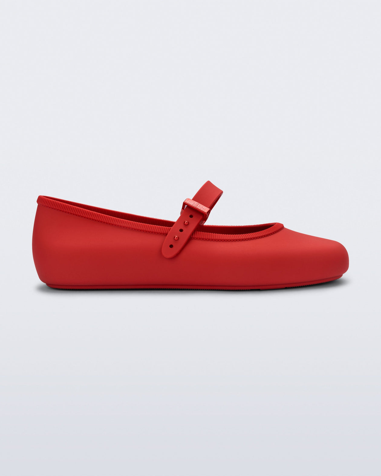 Side view of a red Soft Ballerina flat with top buckle strap