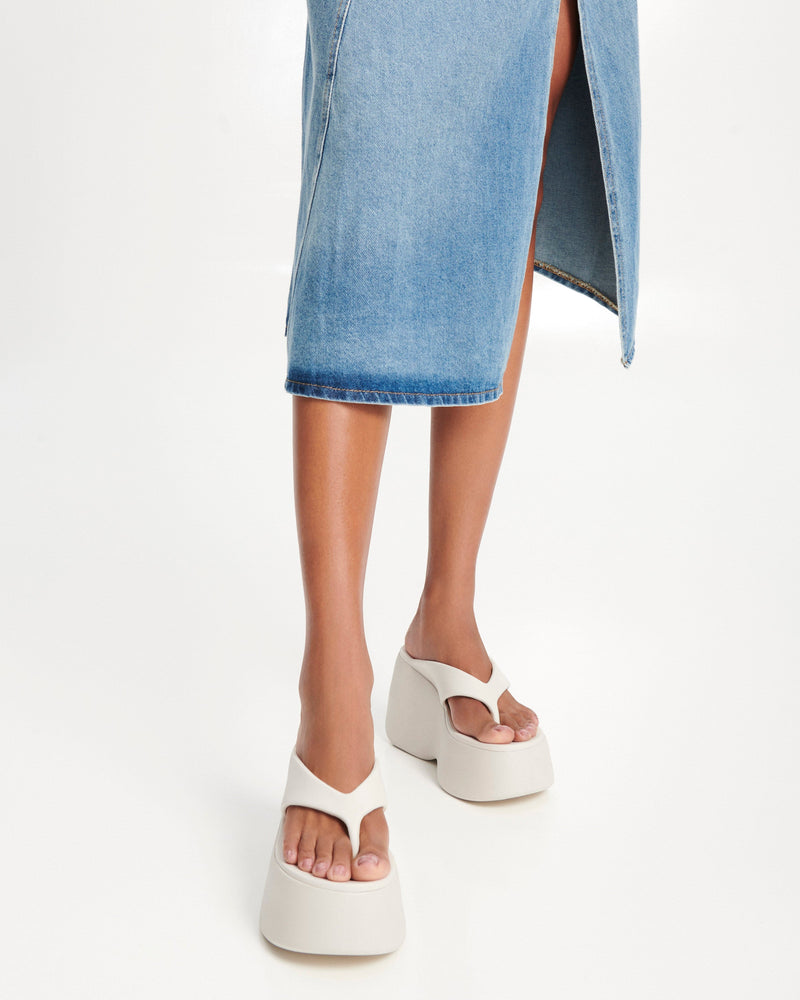 Model's legs wearing a pair of beige Free Thong Wedge Platform heels