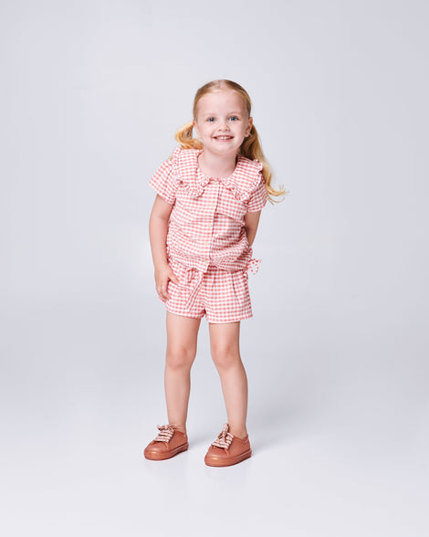Child model wearing a pair of pearly brown baby Hip M Lover sneakers with laces