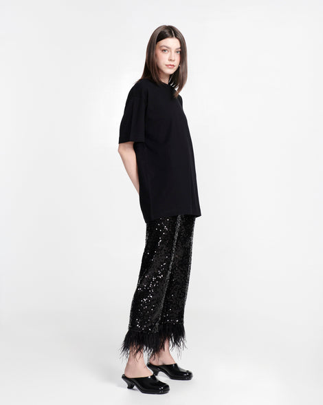 Model in a black outfit wearing a pair of black Gaia kitten heels with peep toe