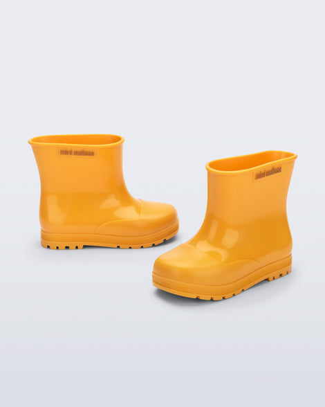 Side and angled view of a pair of orange Welly baby rainboots