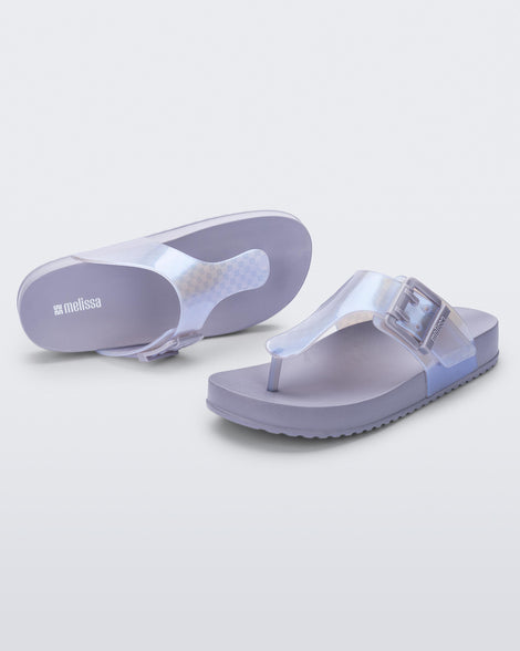 Top and angled view of a pair of pearly blue Cozy Flip flops