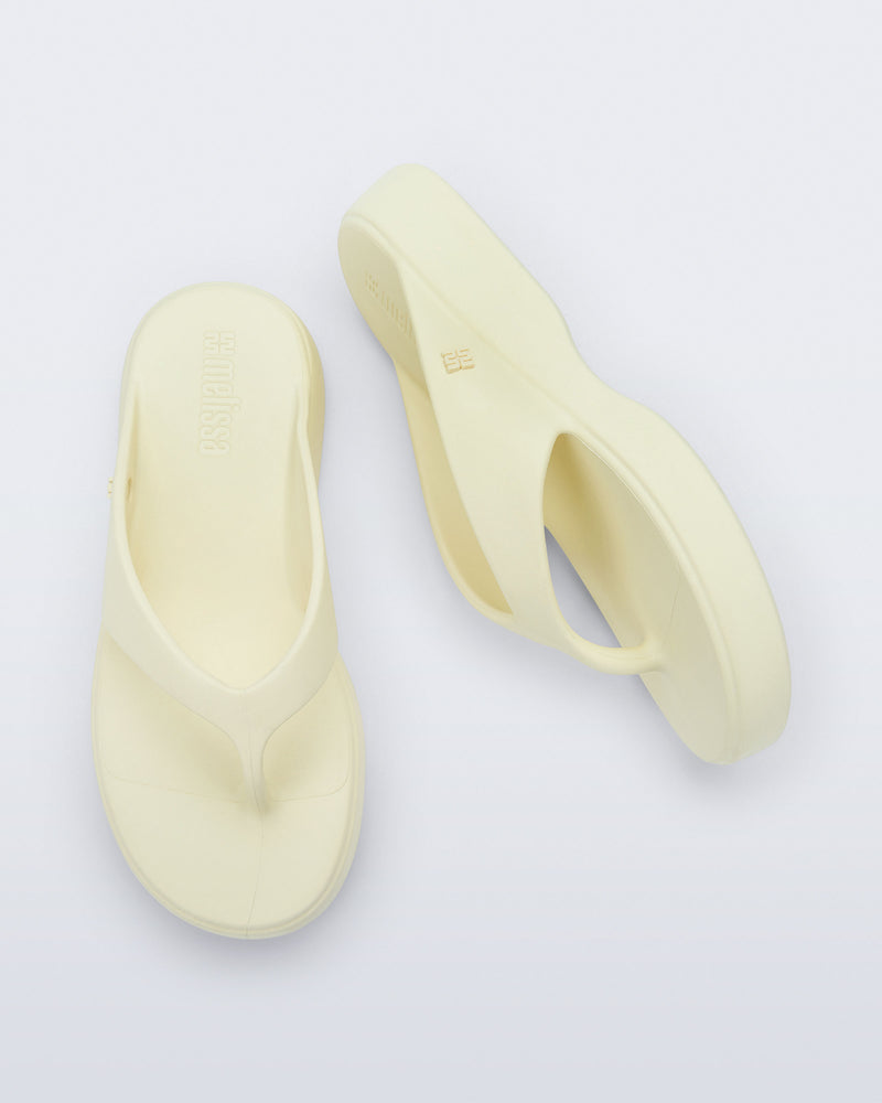 Top and side view of a pair of beige Free Thong Low Flip Flops