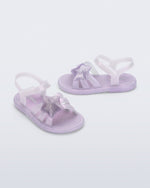 Side and angled view of a pair of pearly purple Hip Sky baby sandals with a glitter purple star on top