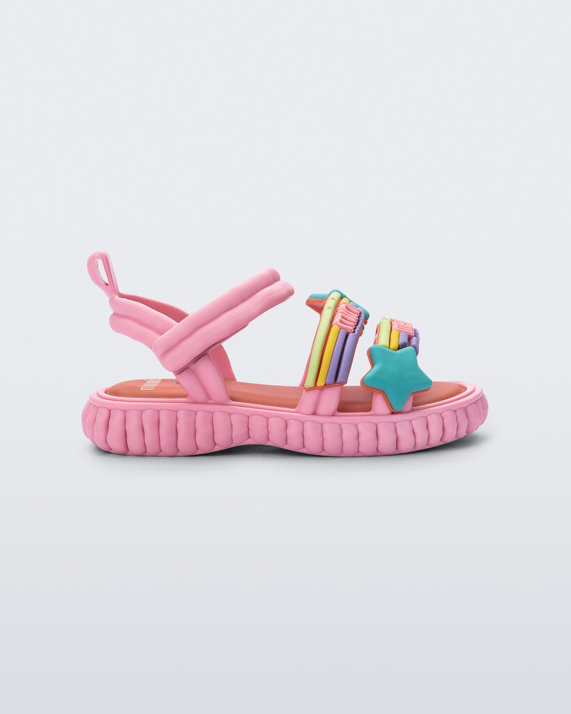 Side view of a pink Create + Play Doh sandal with rainbow and a star straps
