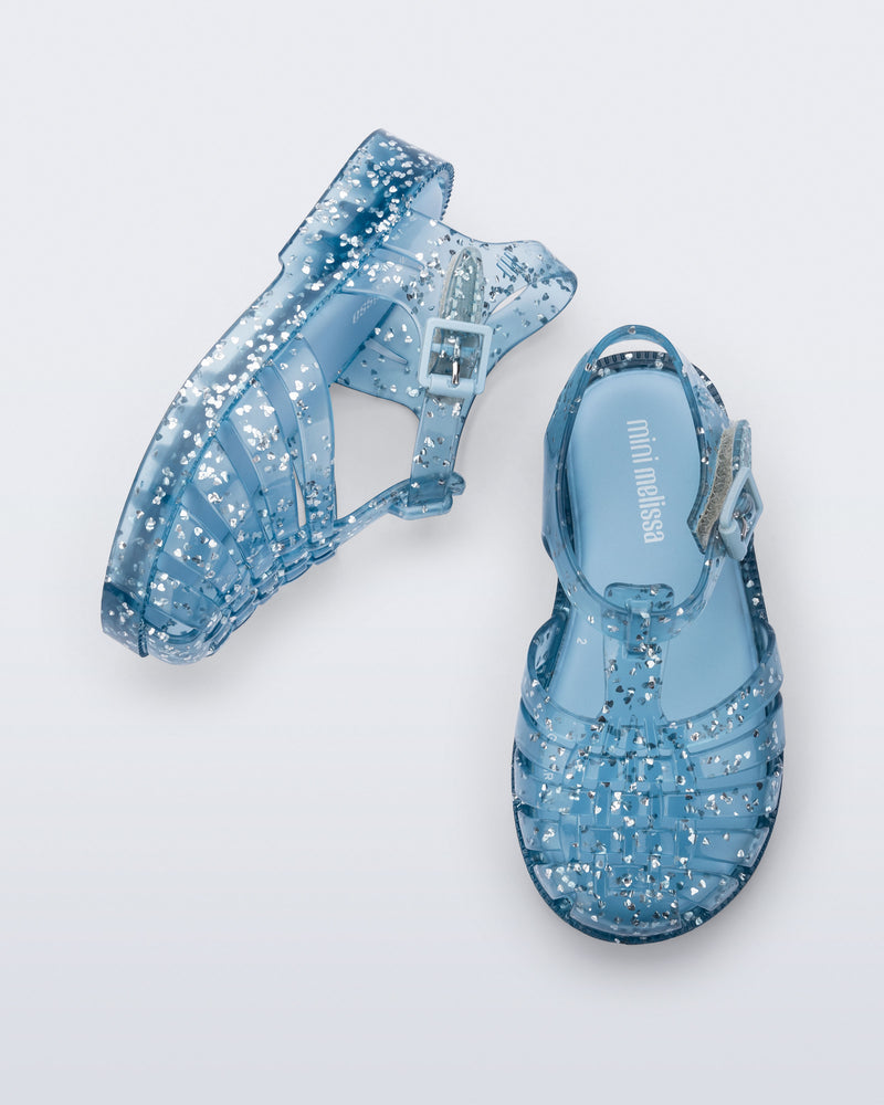 Top and side view of a pair of blue Possession Elements baby sandal with glitter hearts