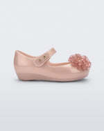 Side view of a pearly pink Ultragirl Springtime baby flat with two clear pink flowers and peep toe.