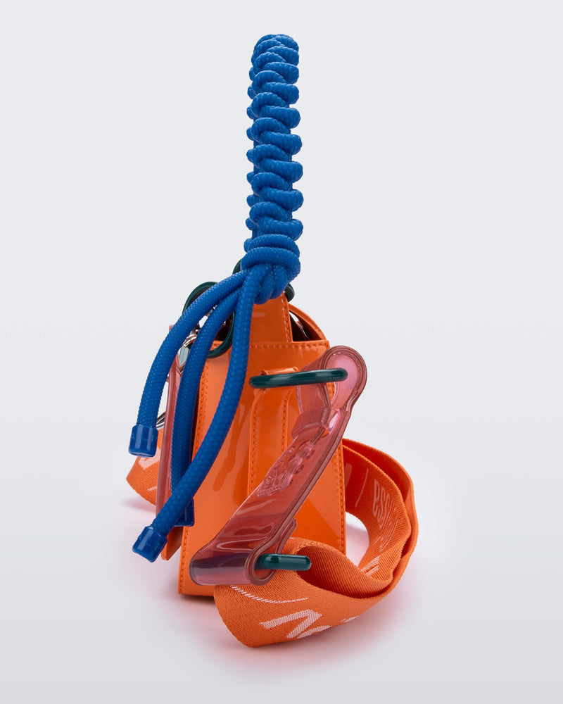 Side view of an orange Olga Bag + Alexandre Pavao with blue short strap fabric long strap